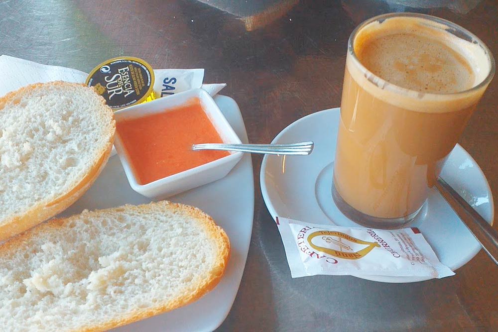 Типичный андалусский завтрак: кофе с молоком, поджаренный хлеб, оливковое масло и протертый томат