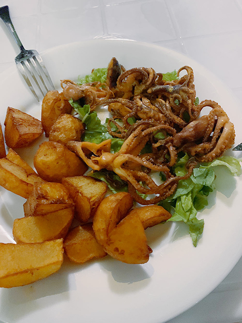 Блюдо из маленьких осьминогов и жареного картофеля