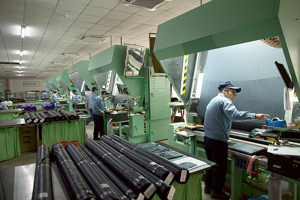 Работники ткацкой фабрики проверяют качество ткани и отмечают брак. Рулон ткани проматывают перед специальной лампой и смотрят на просвет. Готовые рулоны упаковывают в пластик, чтобы защитить от влажности и света