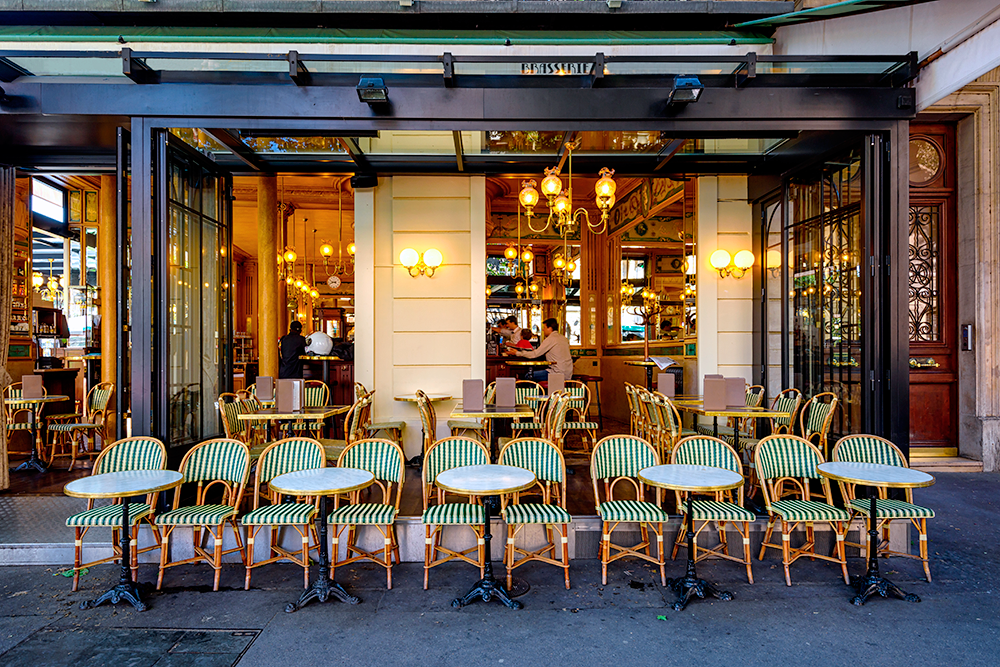 Летом в Париже работает много уютных кафе на улице. Фото: Shutterstock