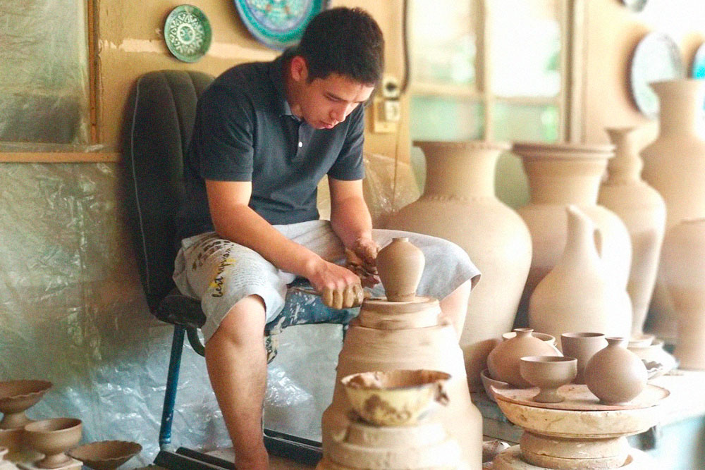 Ученик делает глиняные заготовки на гончарном круге