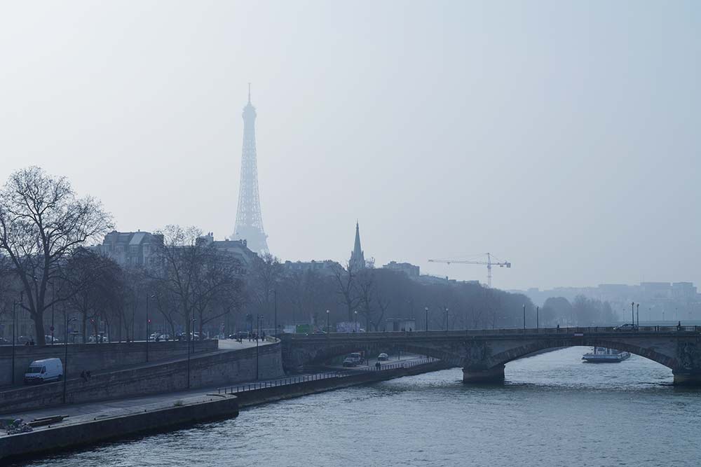 На небе ни облачка, но башня скрыта в легкой дымке — это и есть парижский смог