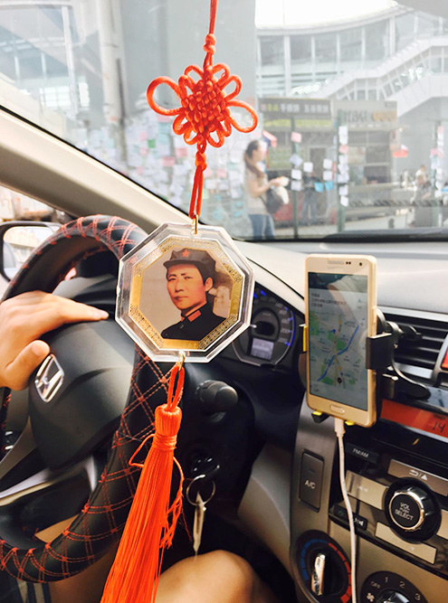 Водители всегда пользуются навигатором, а не сами решают, как удобнее проехать. Этот водитель такси украсил салон портретом Мао Цзэдуна — он все еще в почете в Китае
