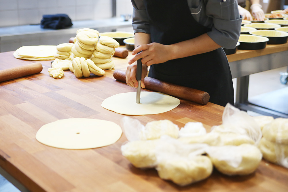 Сотрудники делают пирог: готовят начинку, подготавливают тесто