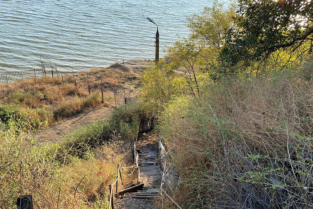 Старая деревянная опасная лестница, по которой жители Богудонии спускаются к морю