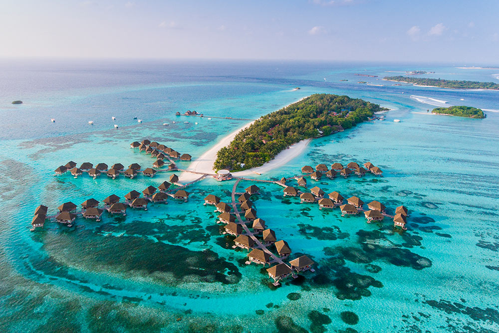 Так выглядит типичный остров-резорт на Мальдивах: маленький остров в зелени и с белоснежным песком в окружении океана. Фото: Siraphob Werakijpanich / Shutterstock