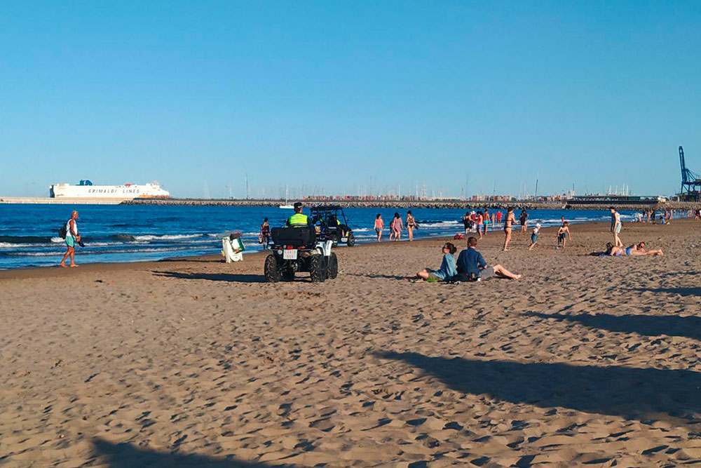 Полицейские перемещаются по пляжу на квадроциклах