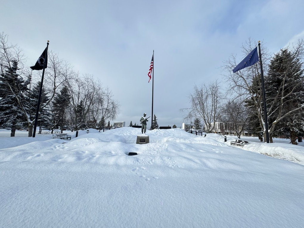 Мемориал ветеранам Аляски (Alaska Veterans Memorial). Справа — флаг штата Аляски, изображающий семь звёзд созвездия Большой Медведицы и Полярную звезду в правом верхнем углу.