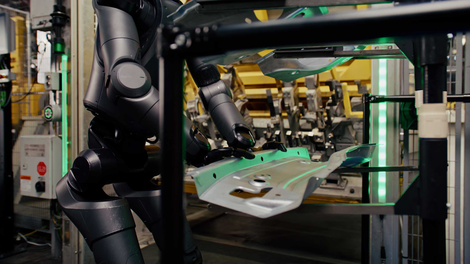 Figure 02 устанавливает листовую деталь в оснастку. Ценность кейса BMW — в опубликованных часах работы и количестве обработанных компонентов, а не только в движениях робота. Источник: BMW Group PressClub