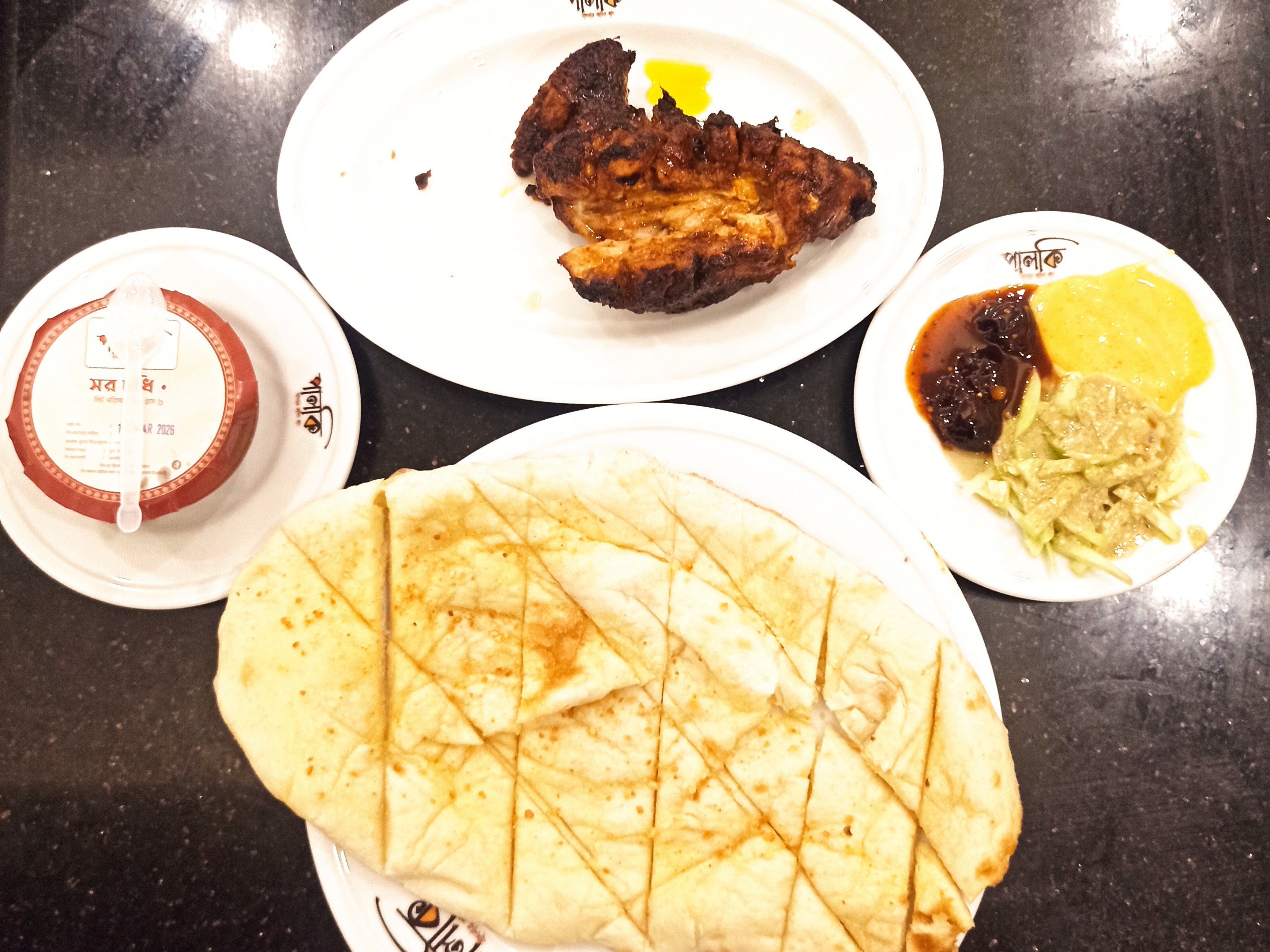 Курица тандури — маринованная в йогурте и обжаренная на открытом огне курица, к которой прилагаются пшеничная лепешка наан и соусы