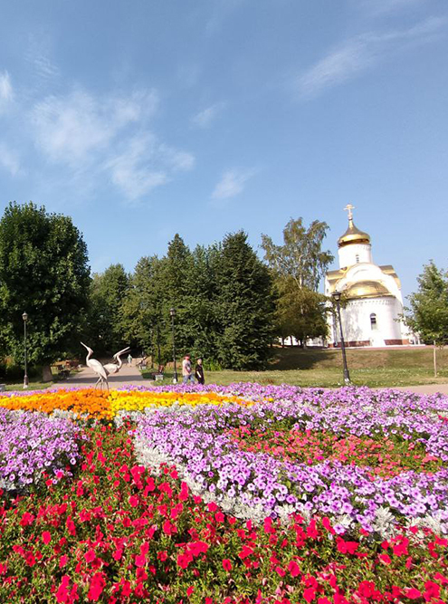 Сквер с видом на цветы, администрацию, церковь и искусственных аистов