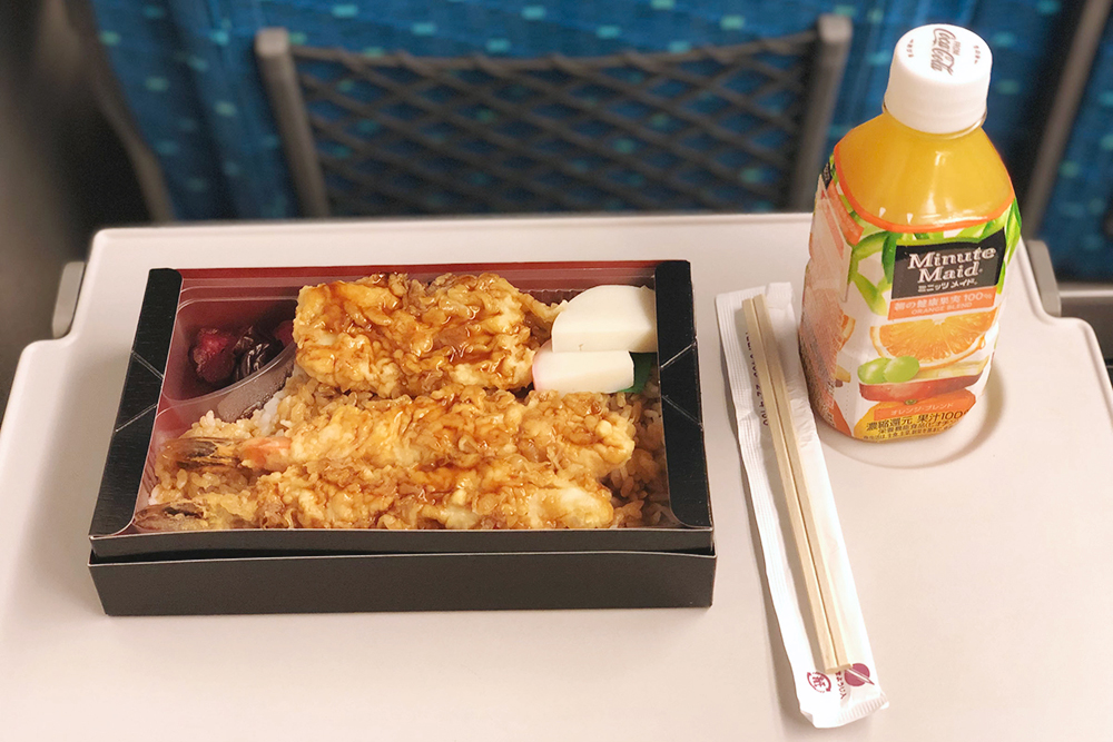 Бенто с креветками в темпуре, рисом и маринованными овощами — 1000 ¥, апельсиновый сок из вендингового автомата — 150 ¥