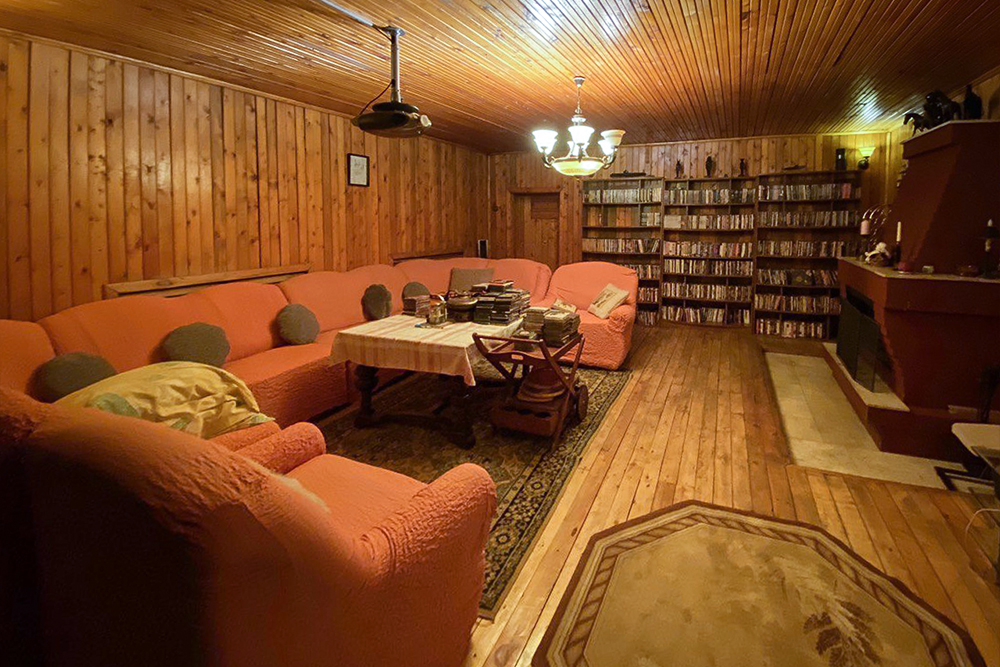 Большой диван и теплые тона, в которых оформлена комната на цокольном этаже, делают ее уютной