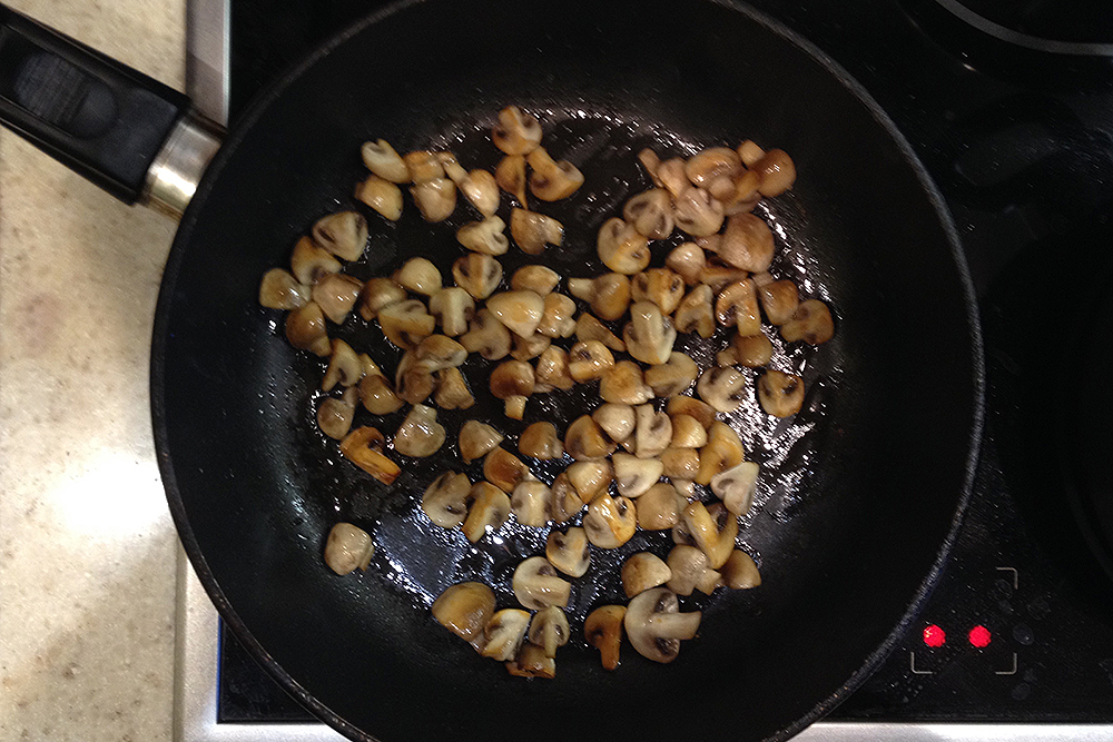 Поджарьте грибы отдельно. В них много жидкости — если добавить их сырыми к готовящейся картошке, блюдо перестанет жариться, а начнет тушиться
