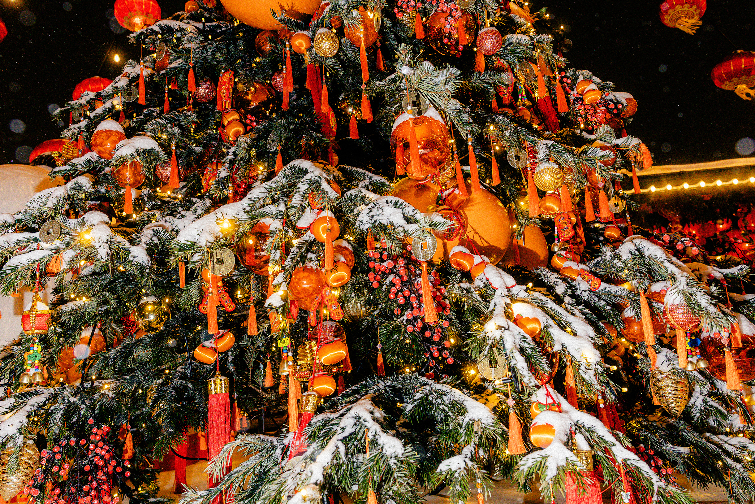 Елки украшены красными китайскими фонариками, золотыми и алыми шарами, подвесками с иероглифами, кисточками, узелками и гирляндами