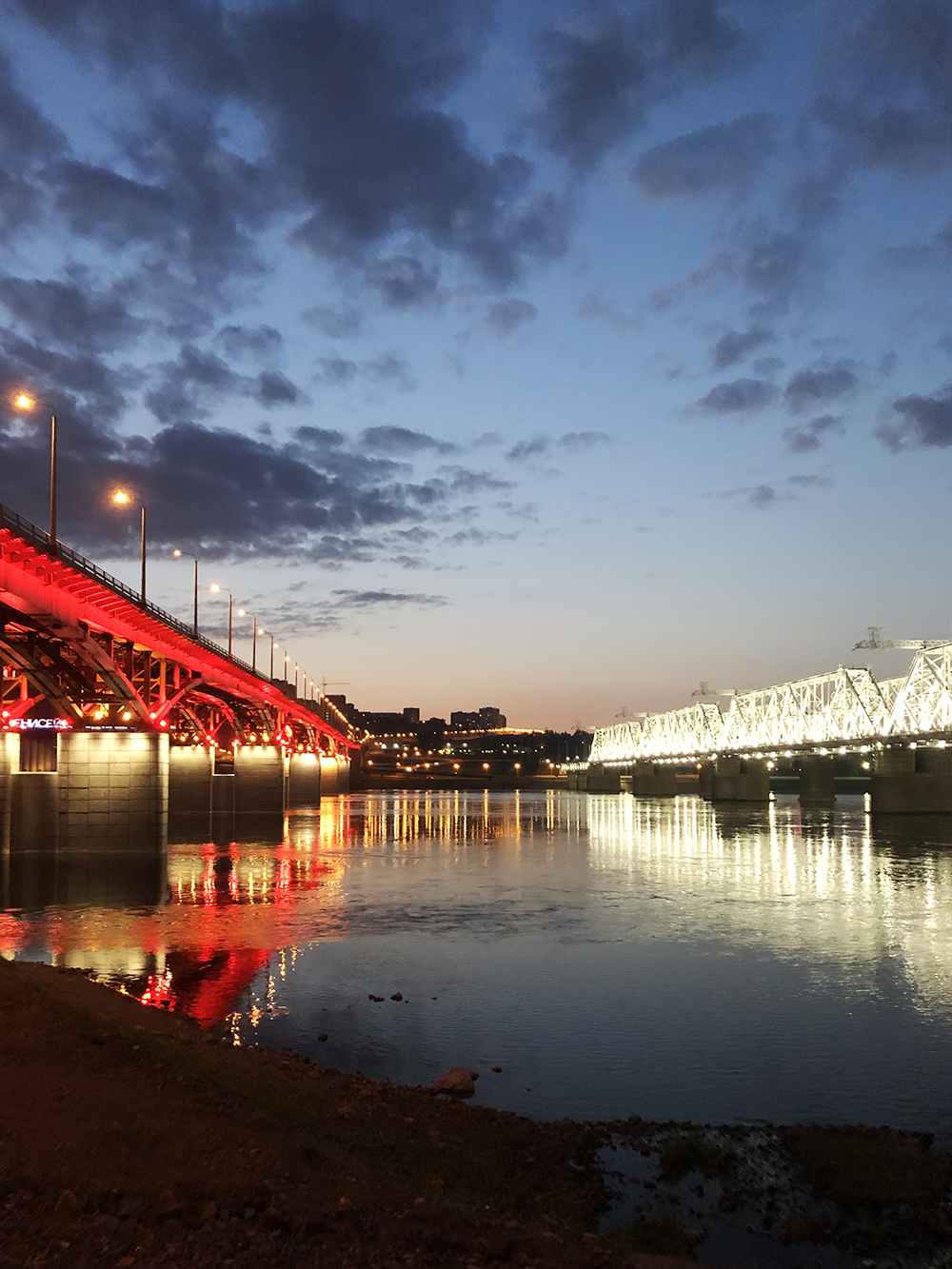 Мост с красной подсветкой — Николаевский, с белой — железнодорожный. На втором фото они же при свете дня