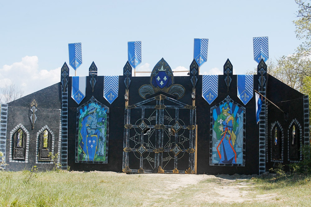 Так выглядели ворота Темерии на крымской ПРИ «Ведьмак» в 2019 году. Эти ворота тоже делала мастерская 31 Cube Craft Studio, а сами мастера играли за темерцев. Слева и справа от ворот изображения по типу витражей, на которых создатели постарались отразить основные события из истории Темерии. Источник: Саша Волк