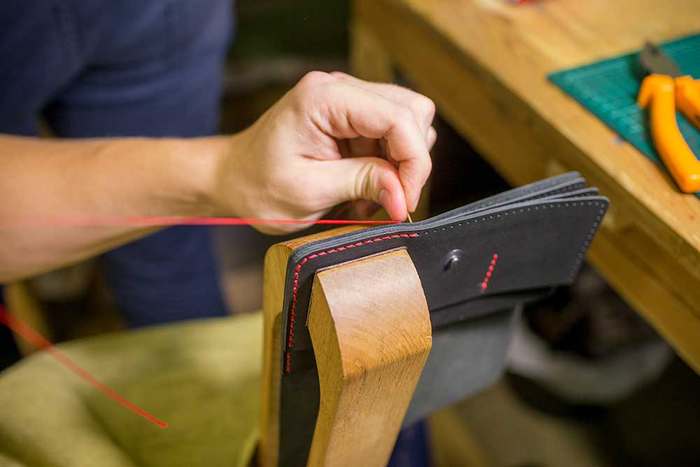 Сшивают детали вместе с помощью шорника — деревянных тисков. Он закрепляется на стол или стул — с ним работать удобнее и быстрее
