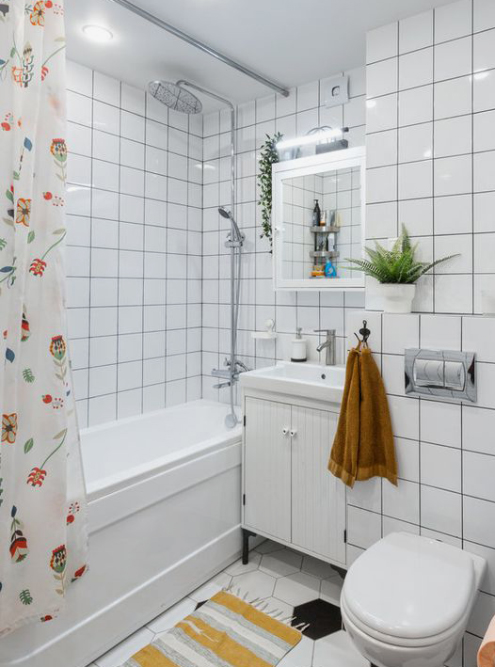 Другой оттенок оранжевого полотенца, который поддержали ковриком и принтом на шторке, смотрится в ванной гармонично. Белая плитка на стенах — прекрасная и недорогая. Источник: inmyroom_ru / Pinterest