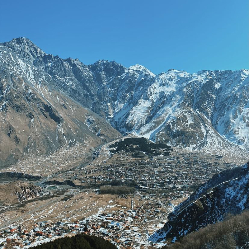 Вид на Казбеги с горы Казбек у церкви Гергети зимой