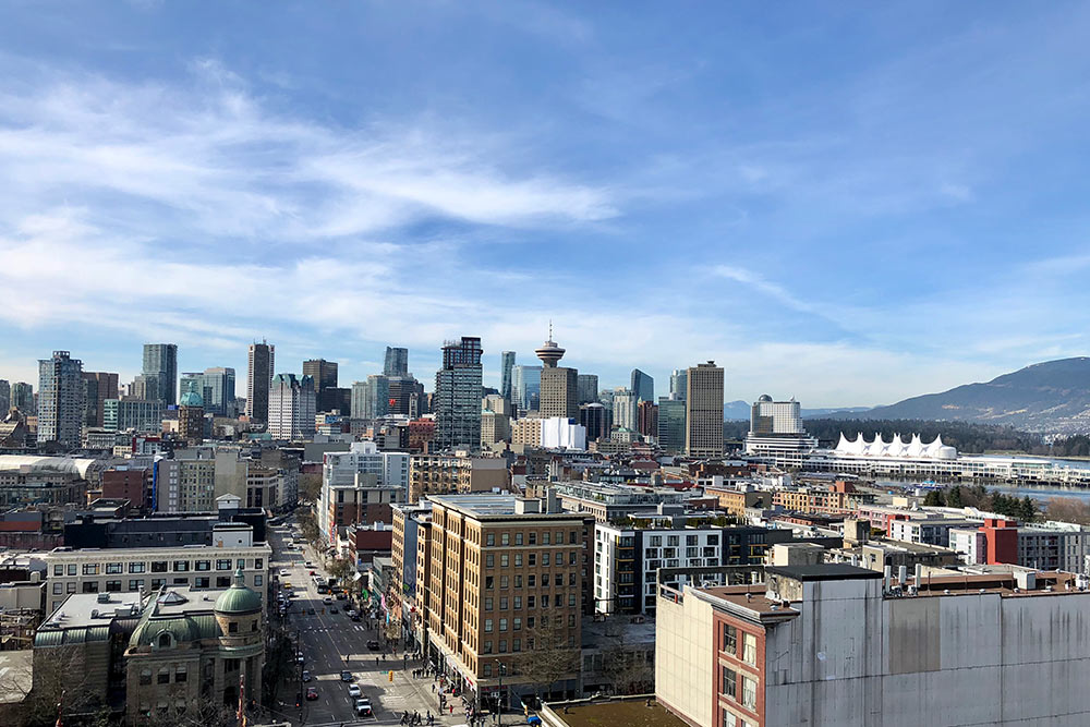 Вид на Ванкувер. Белое здание справа, похожее на шатер, — это комплекс «Канада⁠-⁠плейс». Там проводят большинство массовых мероприятий, например гуляния в День Канады, который празднуют 1 июля