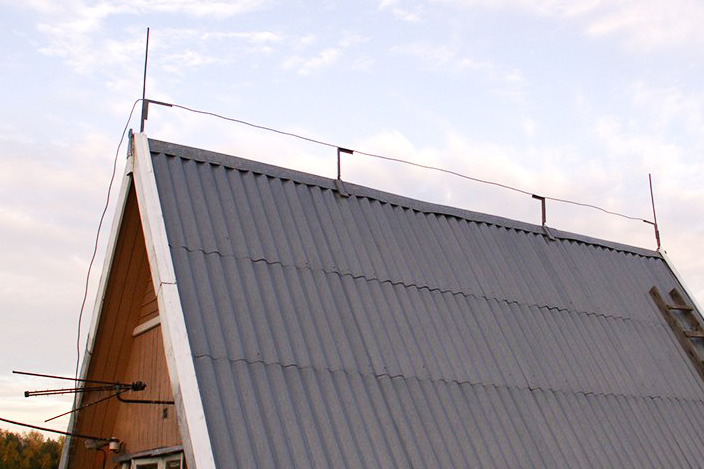 Тросовый молниеприемник иногда комбинируют со штыревым: по краям крыши ставят стержни, а между ними натягивают трос. Источник: «Два молотка»