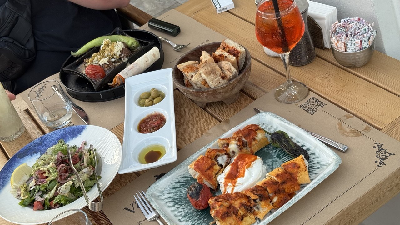 Заказываем овощной салат, апероль-спритц, мохито и два мясных блюда.