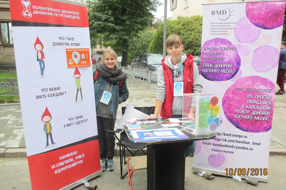 Волонтеры Аня и Лена рассказывают жителям Петрозаводска о донорстве крови и костного мозга на городском празднике «Открытые улицы» в 2016 году