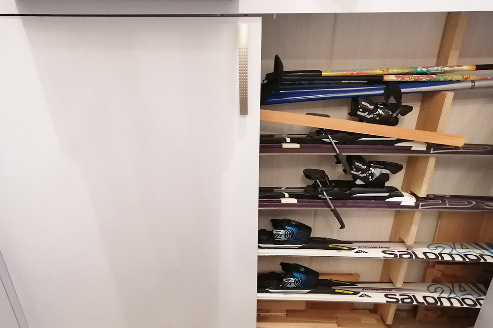 Лыжи прячутся в нижнем шкафу под столешницей