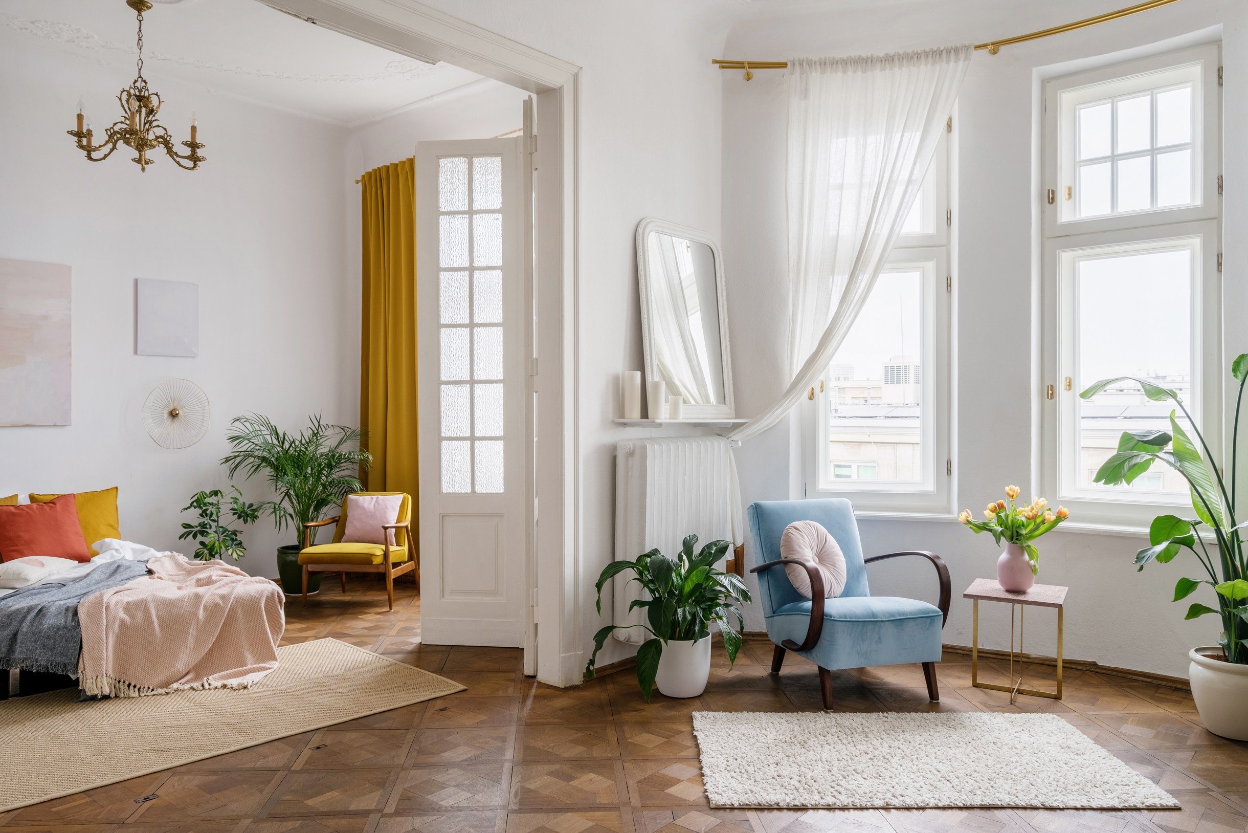 В спальне хорошо смотрятся яркие шторы и декоративные подушки. Можно повесить ретролюстру над кроватью и дополнить интерьер винтажным креслом. Фотография: brizmaker / Shutterstock / FOTODOM