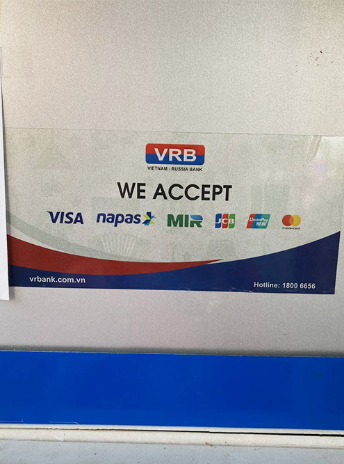 Наклейка на банкомате VRB в центре Хошимина, где обозначено, что он принимает карты «Мир»