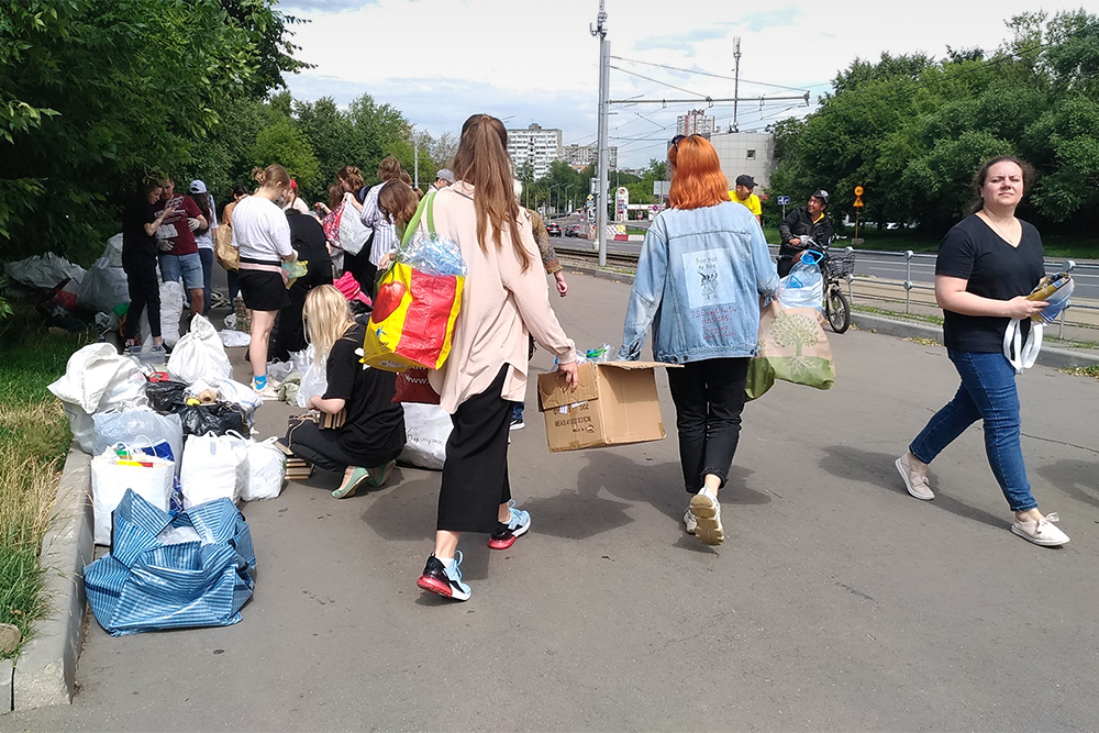 Волонтеры стоят с мешками и контейнерами прямо на тротуарах. Это привлекает внимание прохожих, но никто из местных не жалуется