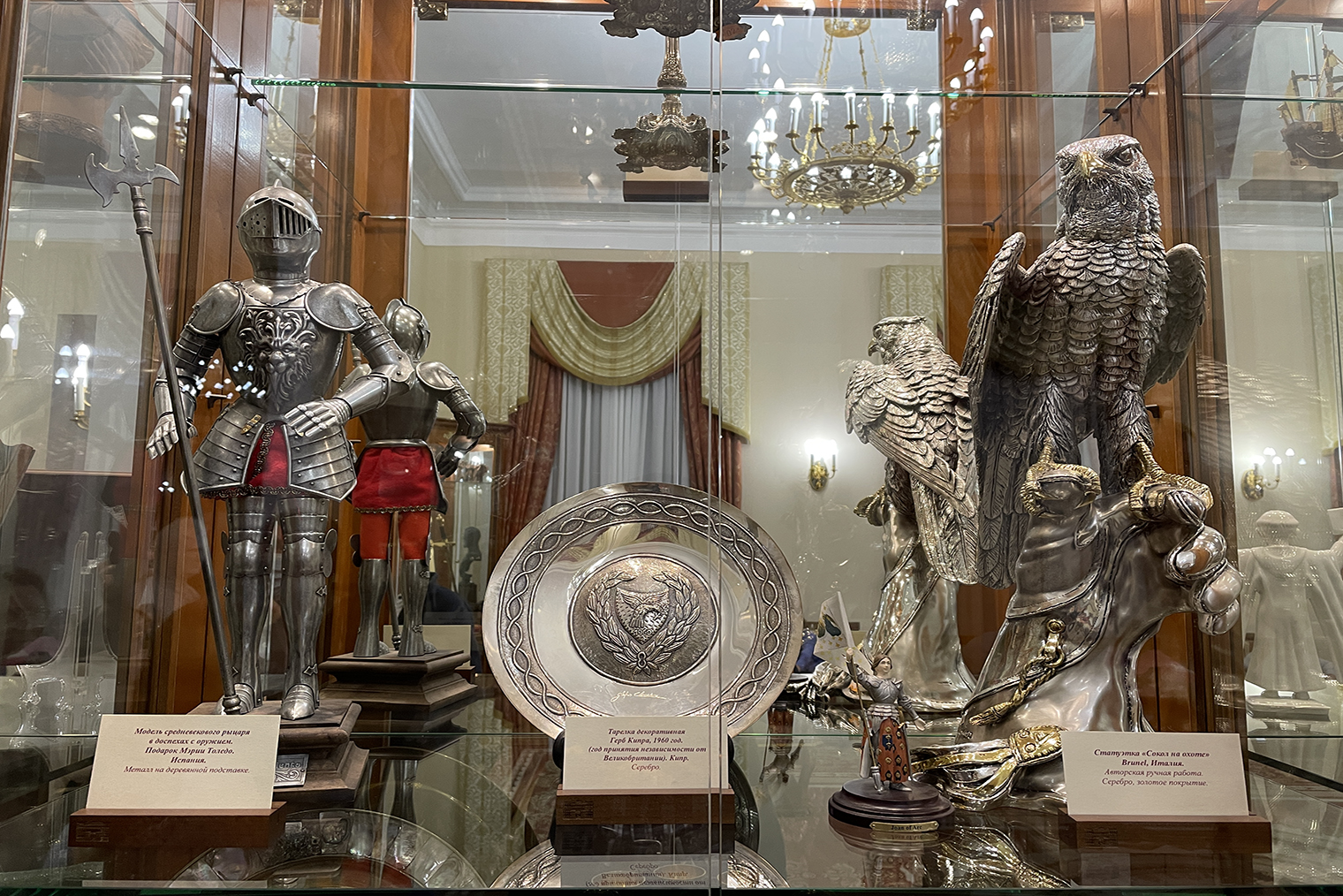 В витрине — фигура рыцаря из Испании, серебряная тарелка с Кипра и статуэтка сокола из Италии