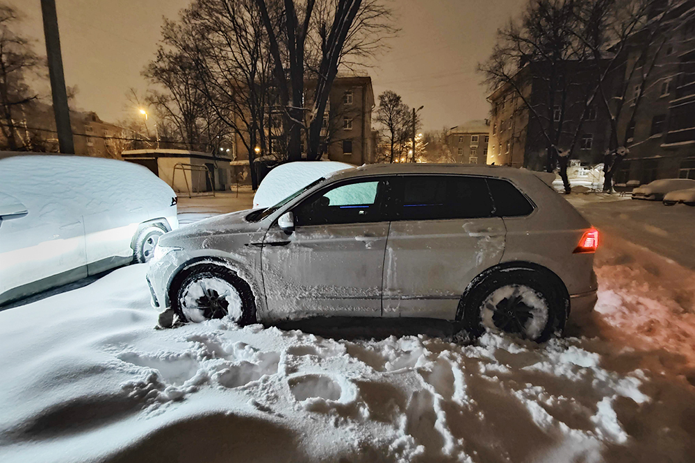 Машина после сильного снегопада проложила во дворе колею
