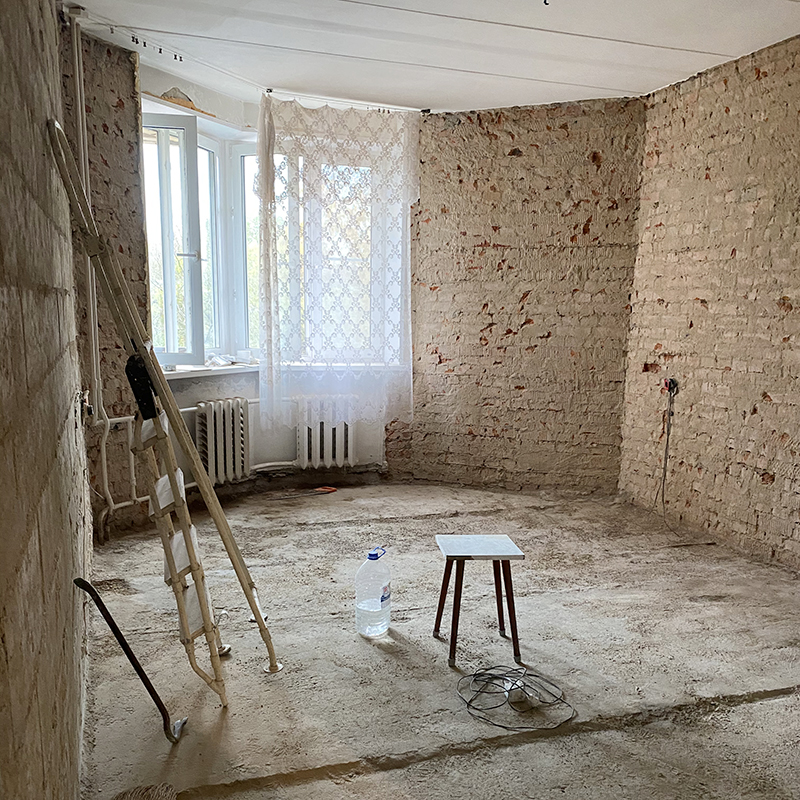После демонтажа в комнате остались только кирпичные стены и бетонный пол