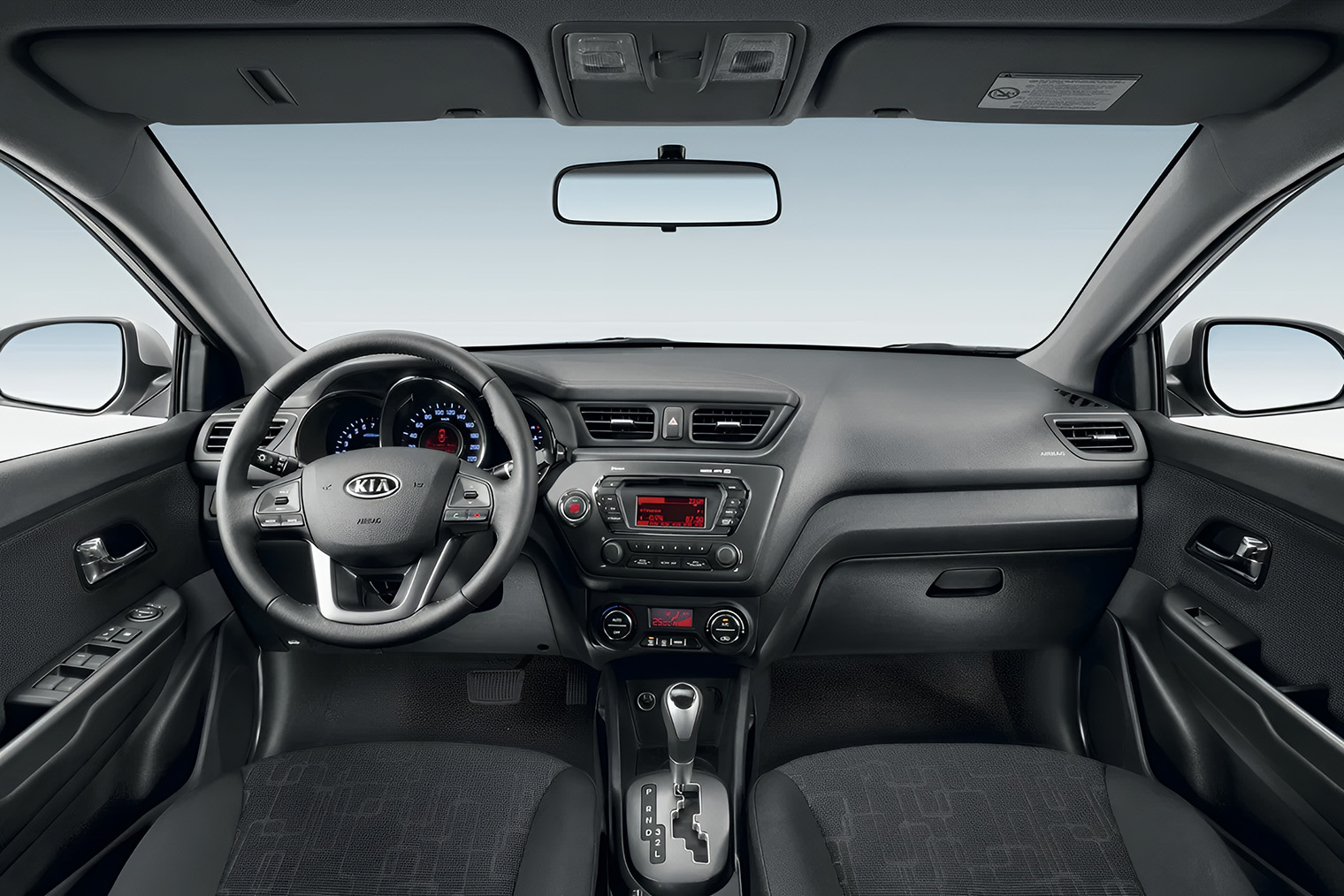 Салон Kia Rio третьего поколения в комплектации Luxe. Рядом с рычагом АКПП появились кнопки подогрева передних сидений. © Kia