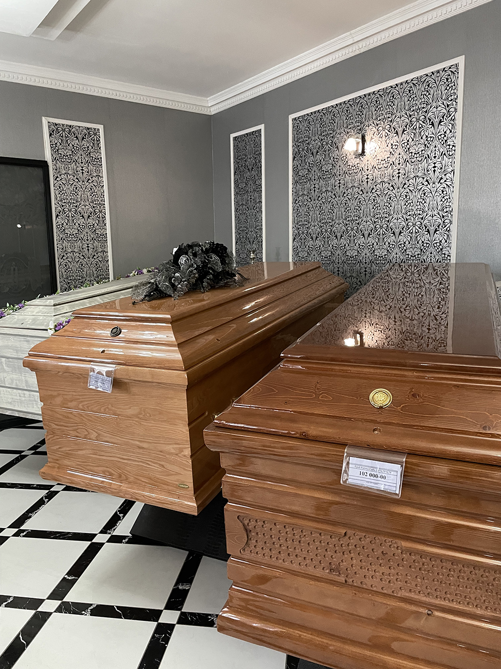 А это уже варианты дорогих гробов: коричневый слева стоит 100 000 ₽, справа — 102 000 ₽