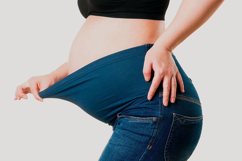 Джинсы для беременных с поясом под животом. Фотография: staras / Shutterstock