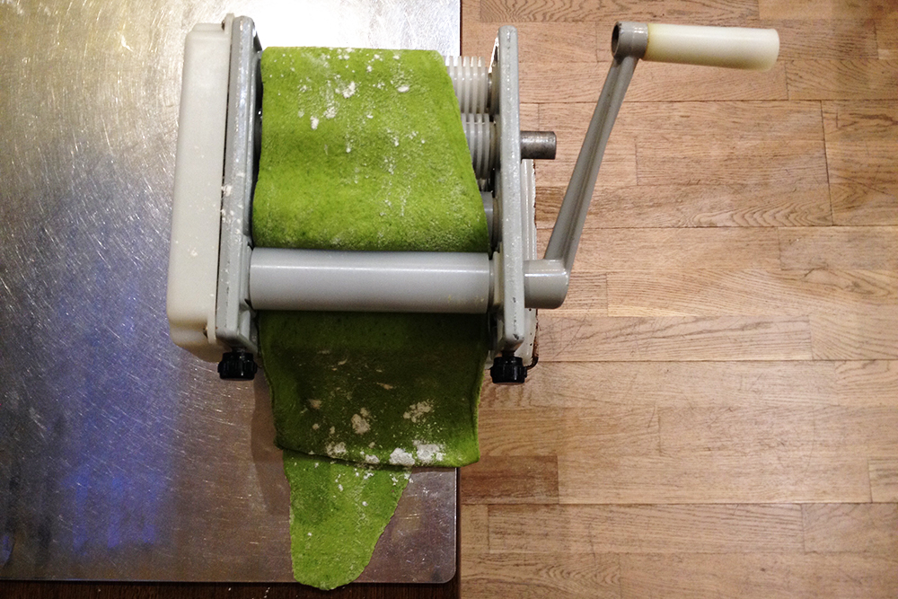 После нескольких прокаток тесто превращается в длинную тонкую ленту. Для удобства его нужно разрезать пополам, а то и на три части