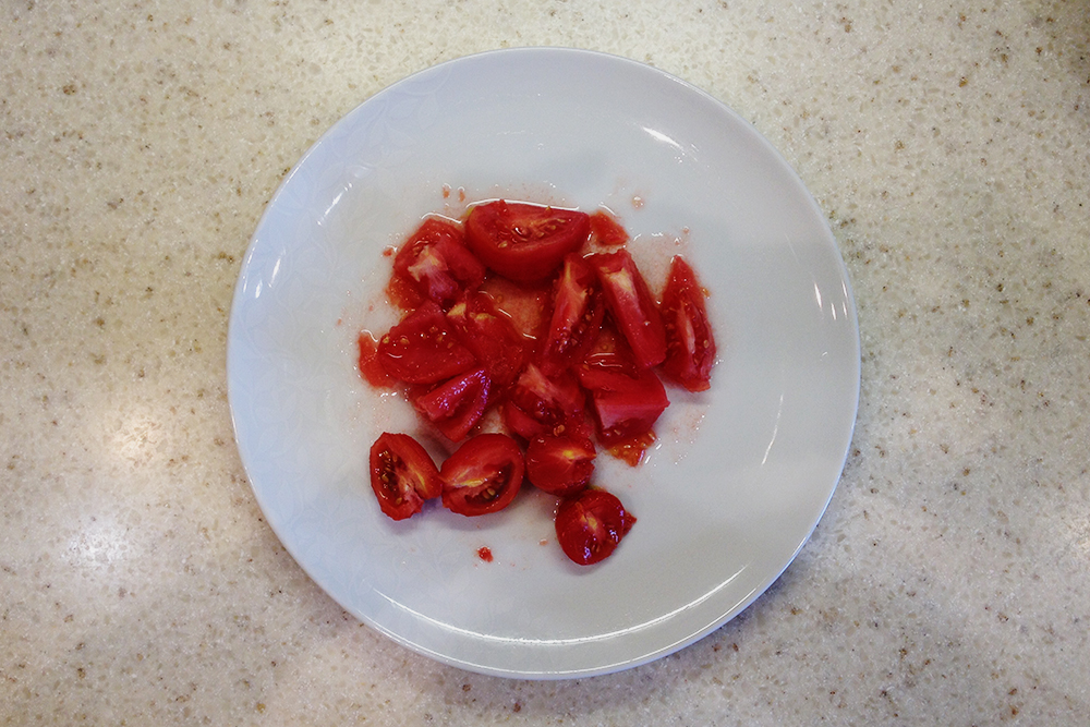 Нарежьте томаты на небольшие дольки, облегчая работу блендеру