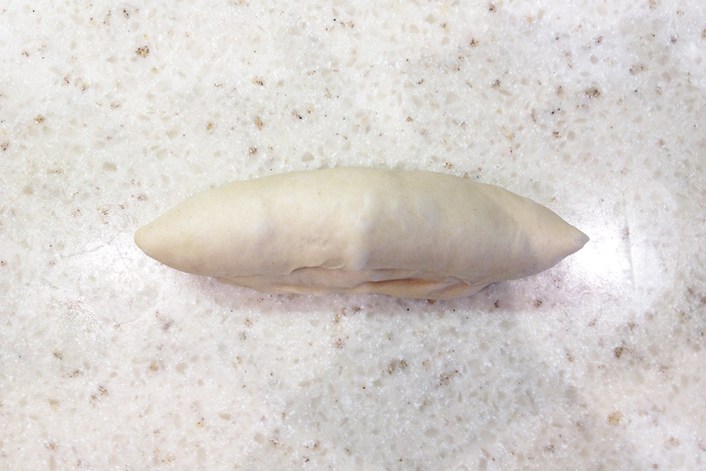 Заверните края лепешки внутрь, формируя колбаску