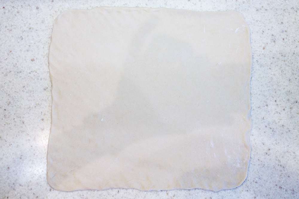 Раскатайте подошедшее тесто в прямоугольный пласт