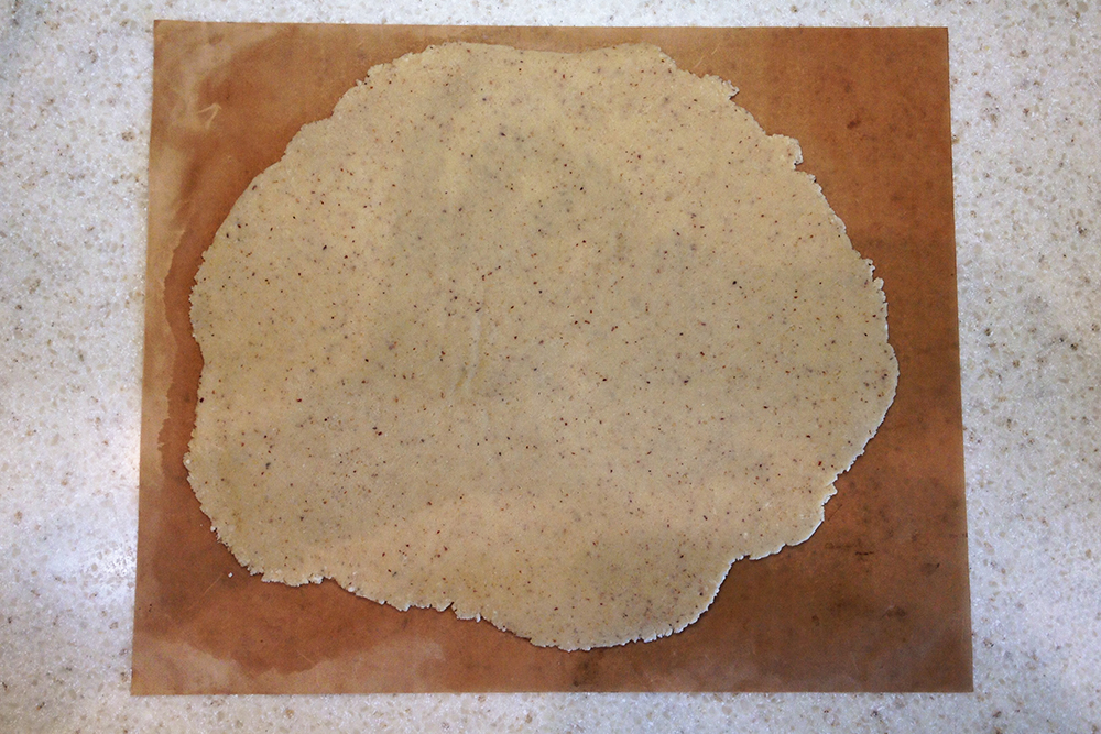 Раскатайте тесто в тонкий пласт между двумя листами пергамента или ковриками для выпечки