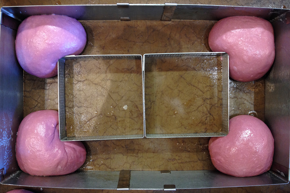 В розовых бургерах только булочки были в форме сердечек, а котлеты — круглые. Но у меня нет форм в виде сердца, поэтому пришлось обходиться подручными средствами. Это три формы для выпечки: внешняя — раздвижной прямоугольник, две внутренние — перфорированные формы для тарталеток 8 × 8 см. Получились неидеальные сердца, но в итоговом блюде они угадывались