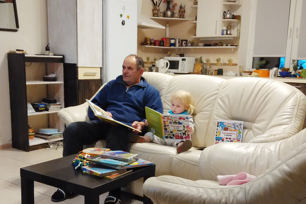 Мой отец с внучкой читают в гостиной дома в Новой Москве