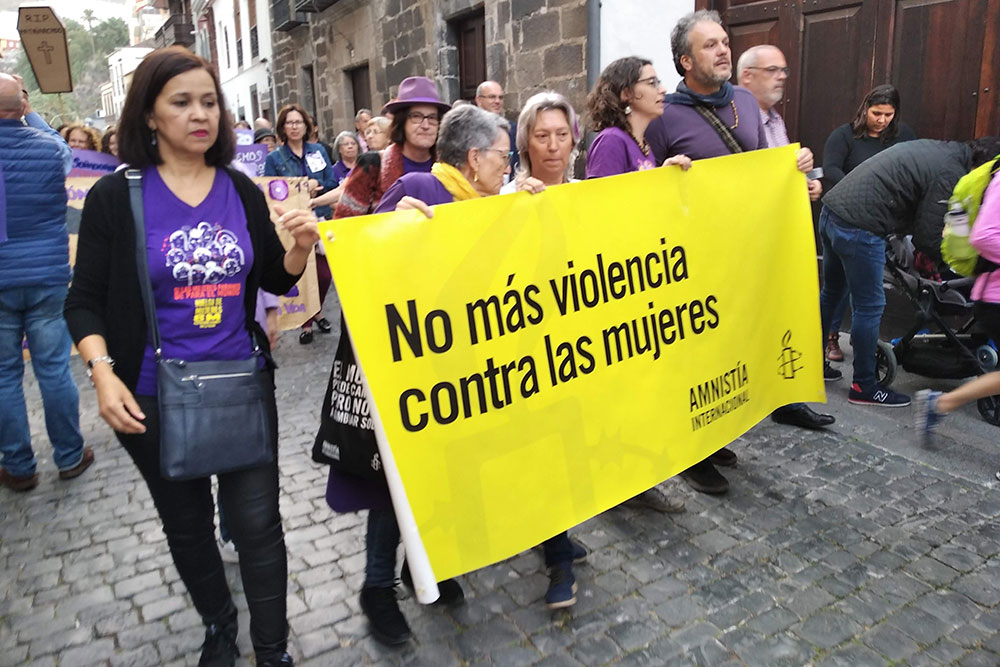 Празднование 8 Марта. На плакате написано: «Нет насилию против женщин»