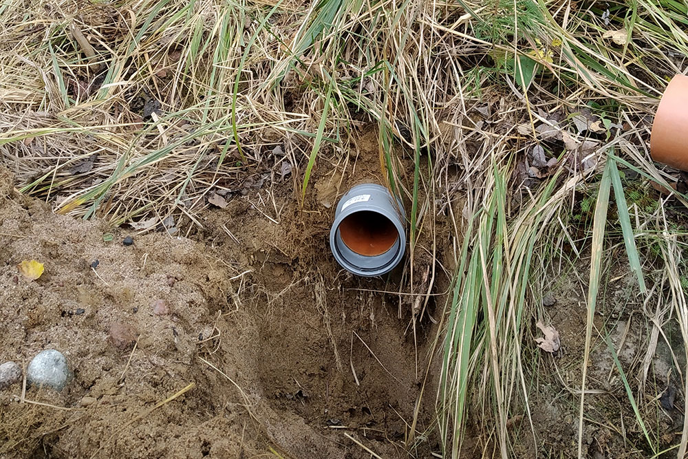 Выпуск внутренней канализационной системы проходит сквозь фундамент и выходит под землей