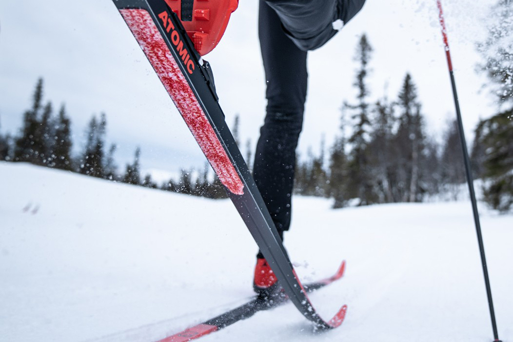 Красная вставка на лыже — это камус. При скольжении камус не должен цепляться за снег и тем самым тормозить лыжу, а при отталкивании лыжа должна легко прижиматься к снегу и не проскальзывать назад. Источник: «Кант»