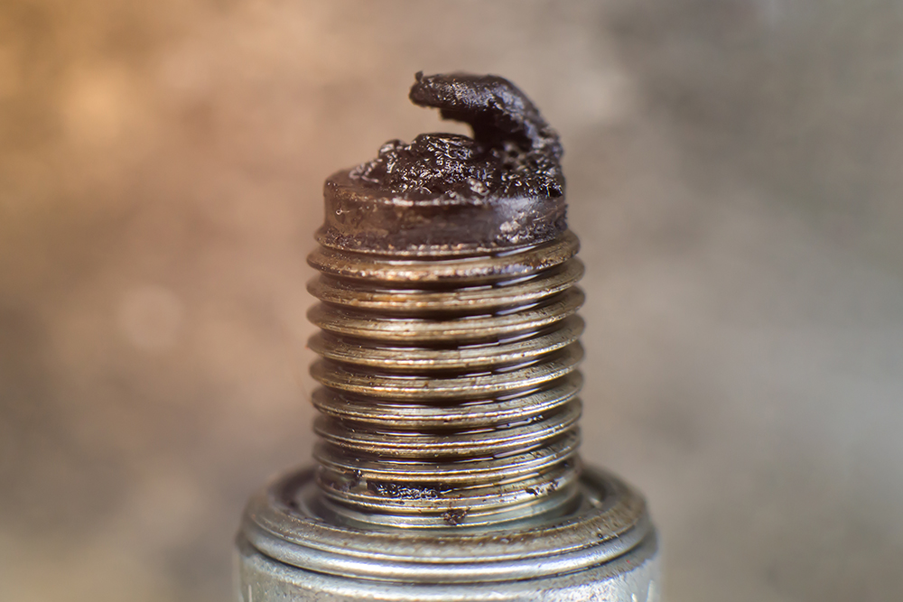 Свеча в моторном масле. Двигатель, из которого ее выкрутили, требует серьезного ремонта или замены. Источник: Chaowalit jaiyen / Shutterstock