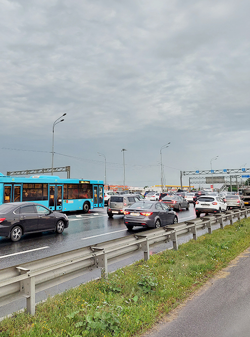 Пробка в 21:00 пятницы на Пулковском шоссе. Чуть поодаль можно разглядеть надземный пешеходный переход. Его построили, чтобы все ехало, но в реальности пробка никуда не исчезла